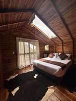 Habitación de la cabaña Dulce Bourbon con claraboya y cama con vista al balcón